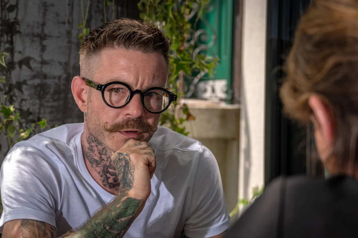 Man sieht den ehemaligen Fotografen Oliver Baer im Gespräch.